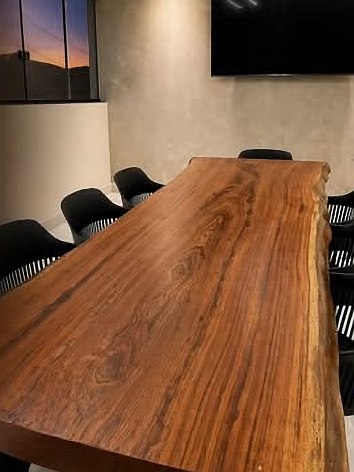 Mesa longa de prancha maciça em sala de reunião